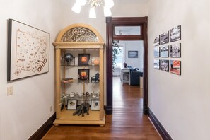 A hallway with a decorative cabinet, framed artwork, and a series of black-and-white photographs on the walls. - Spacious 3BR/3BA Riverfront Retreat with Private Balcony & Sweeping Ohio River Views (New Richmond)