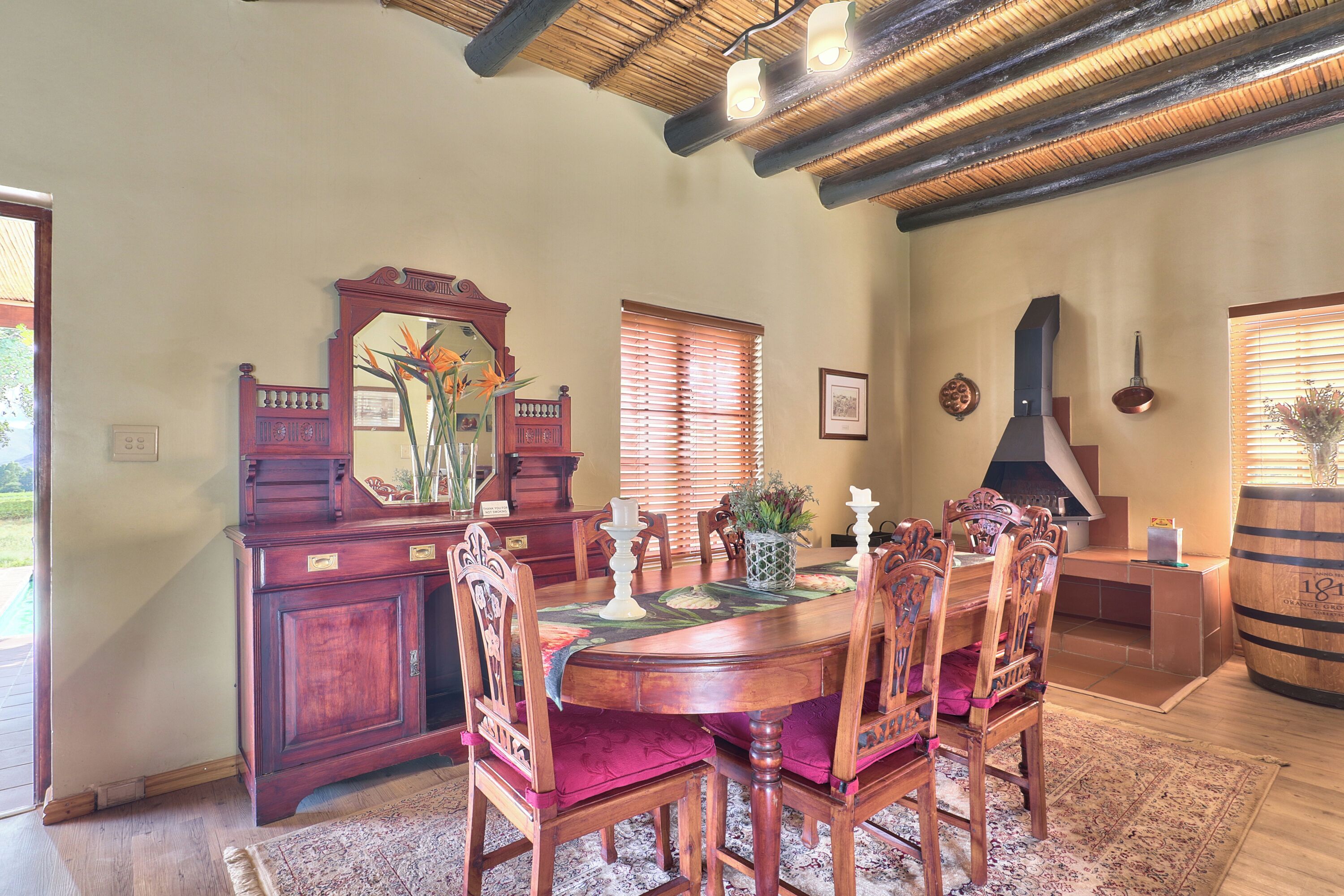 A dining area with a wooden table, chairs, and a large mirror.
