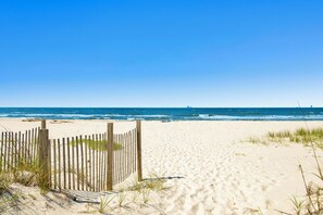 A sandy beach with a wooden fence and waves in the background. - BRAND NEW Pool! Just 100 steps from Beach! Private Fort Morgan Area! (Gulf Shores)