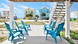 A wooden deck with blue chairs and a wooden pergola.