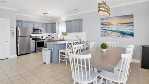 A modern kitchen with grey cabinets, stainless steel appliances, and a central island with seating.