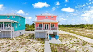 Two beach houses with separate porches and a shared deck area.