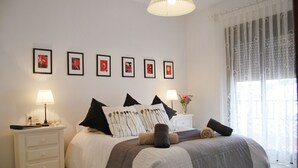 A neatly arranged bedroom with a bed, nightstands, and framed pictures on the wall. - Ap140 Alcazaba 2D (Nerja)