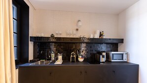 A modern kitchen with a black countertop, stainless steel sink, and a microwave. - Passocean 1 - Suite in the Heart of Honfleur - Kingsize Bed - Airco (Honfleur)