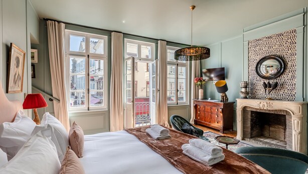 A hotel room with a large bed, a fireplace, and a view of the city. - Passocean 2 - Elegant Suite in the Heart of Honfleur - Kingsize (Honfleur)