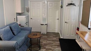 A compact living space with a blue sofa, a small round table, and a ceiling fan.