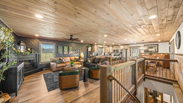 Un vaste espace de vie de style loft, doté d’un haut plafond, de planchers en bois et d’un coin salon confortable.