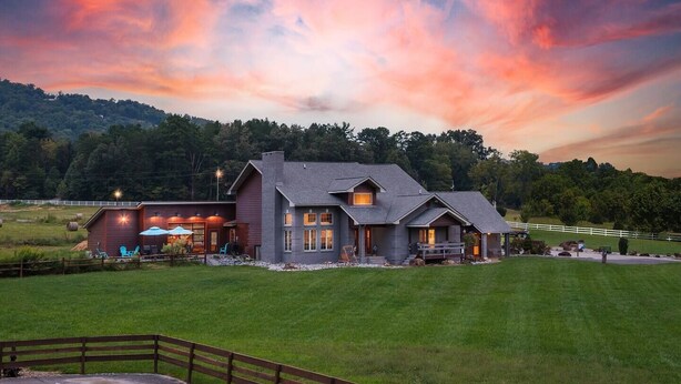 A large, two-story house with a spacious front yard and a well-maintained lawn. - Family Retreat - Pool, Game Room, Theatre, Bowling (Sevierville)