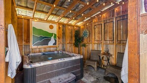 A wooden cabin with a hot tub, a painting of a landscape, and a dartboard. - Cozy Honeymoon Cabin w/ Mtn Views-Hot Tub-Fire Pit (Sevierville)