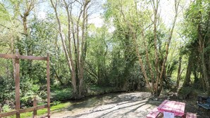 A gravel path leading through a forested area with a picnic table and bench. - Yew Tree House (Ballindaggan)
