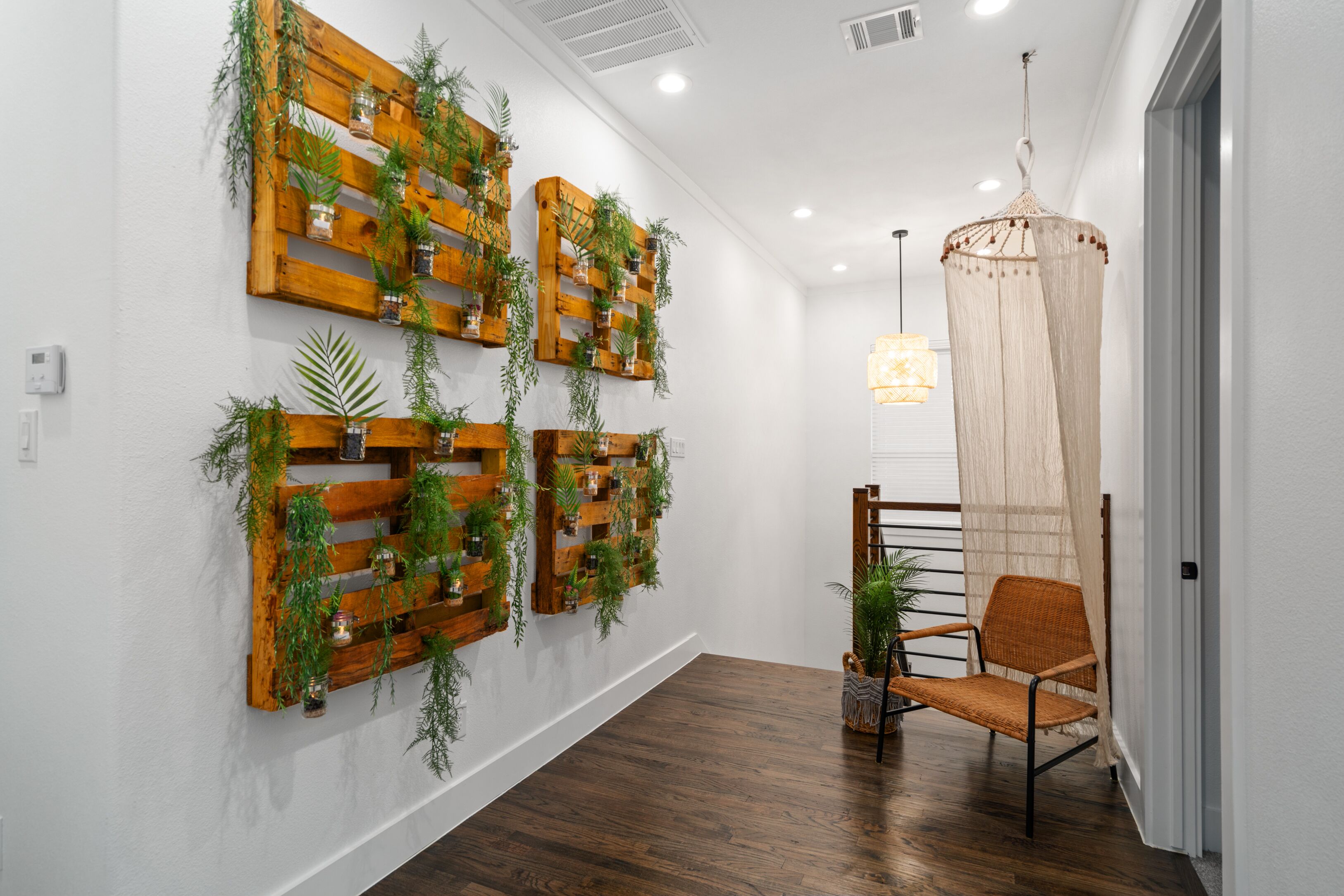 A hallway with wooden wall-mounted planters, a chair, and a hanging light fixture.