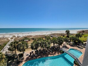 A resort with a pool, beach, and palm trees. - Monterey Bay by Escape (Myrtle Beach)