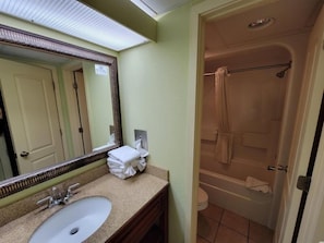 A bathroom with a sink, mirror, and a shower. - Monterey Bay by Escape (Myrtle Beach)