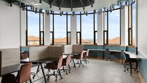 A conference room with a curved ceiling, large windows, and a view of buildings outside. - The Archer Aparthotel by Totalstay (Sandton)