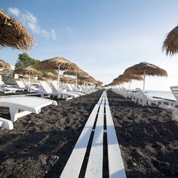 On the beach, black sand, beach umbrellas, beach towels