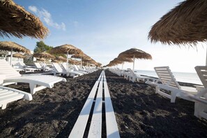 Plage, sable noir, parasols, serviettes de plage