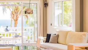 A modern living room with a glass coffee table, a white sofa, and a view of the outdoors. - Cubo's Gibralfaro House Center / private pool / air conditioning (Málaga)