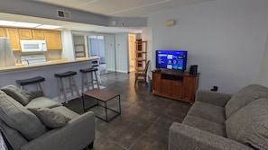 Relax in this cozy living space with a sectional sofa, flat-screen TV, and kitchenette.