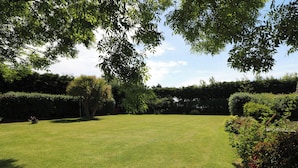 A well-maintained lawn with a variety of trees and shrubs, providing a natural and serene outdoor space. - Tilladavin House (Kilmore)