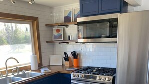 Una cocina moderna con estufa integrada, horno, microondas y refrigerador de acero inoxidable.