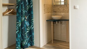 A bathroom with a glass sink, a mirror, and a shower curtain with a leaf pattern. - Maison Avec Jacuzzi, Calme ET Detente EN Nature (Chepy)