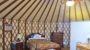 A room with a bed, a wooden cabinet, a desk, and a chair. - Yurt Floating in the Forest (Holts Summit)