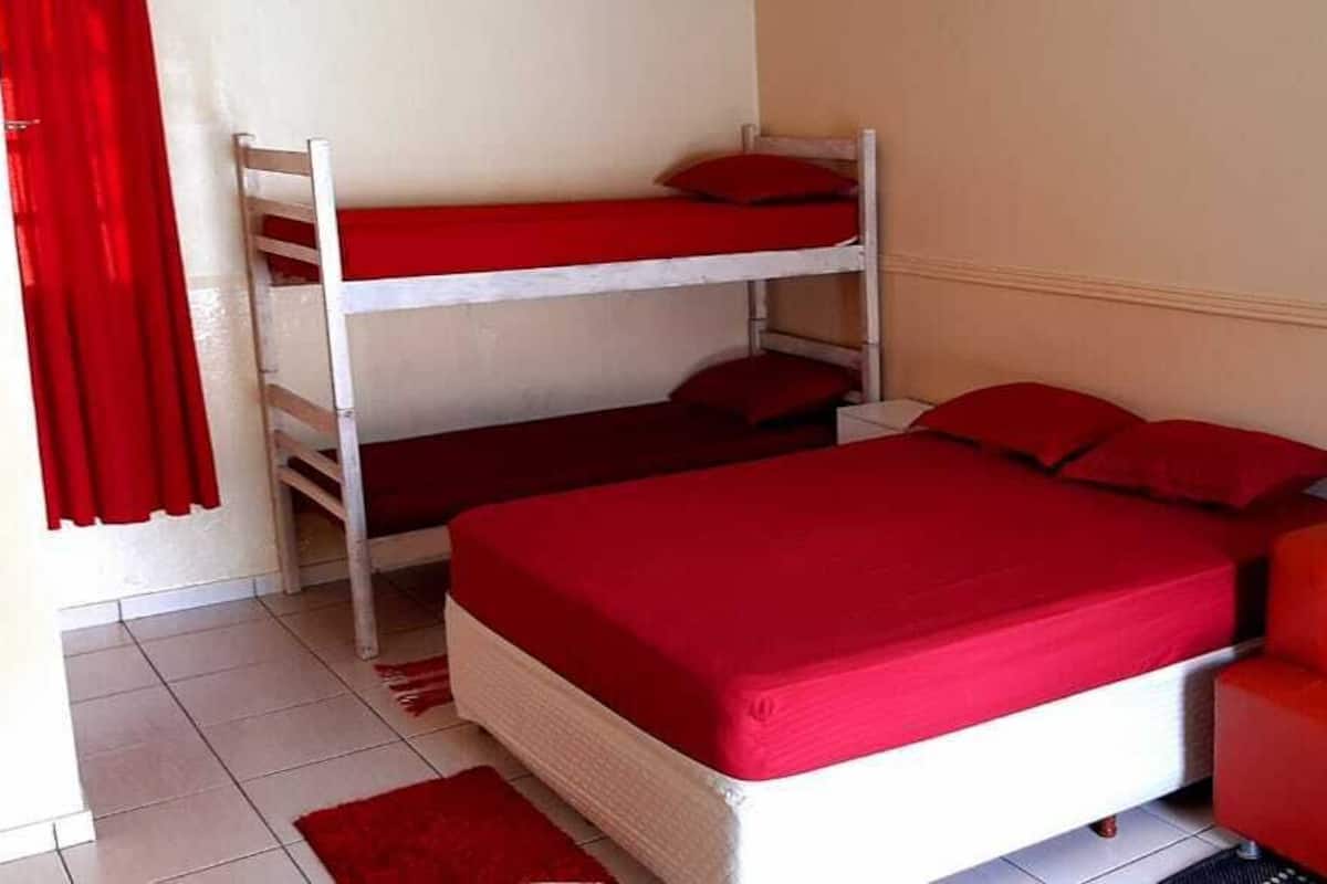Une chambre avec des lits superposés et un canapé rouge.