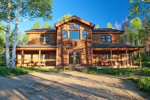 A two-story log cabin with a porch and outdoor seating. - Gold Camp - A Classy-Rustic Gem (Clark)