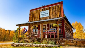 Une cabane rustique en rondins, avec une enseigne indiquant « Columbine General Store Cabins ».