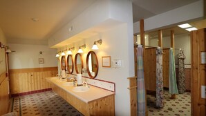 Une salle de bain d’hôtel dotée de plusieurs lavabos, de miroirs et de panneaux de bois.