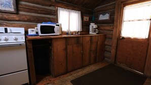 A compact kitchen with a microwave, coffee maker, and stove. - Honeymoon Cabin - A Romantic 2 Person Cabin (Clark)