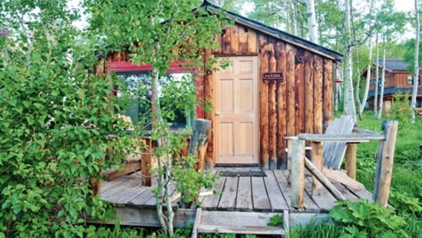 A rustic wooden cabin with a wooden porch and a door marked "BAKER". - Bakers Cabin - A Cozy Rustic One-Room Cabin (Clark)