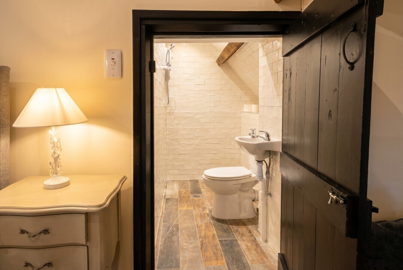A bathroom with a toilet, sink, and shower.