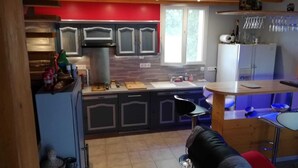 A compact kitchen with modern appliances, a dining area with a bar, and a visible window.