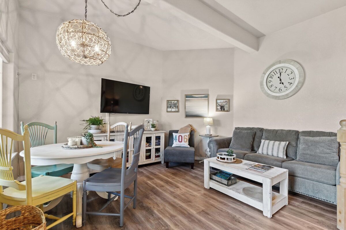 A living room with a television, sofa, coffee table, and dining area.