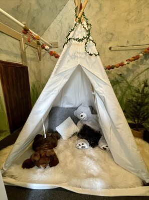 Cozy tent with plush furnishings and a festive atmosphere.