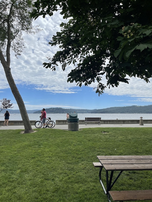 Relax and unwind in a serene park setting with a picturesque view of the water, perfect for outdoor dining and leisure activities.
