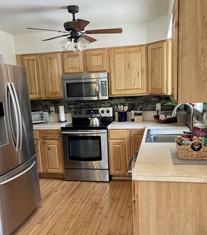 Enjoy cooking in this well-equipped kitchen with a refrigerator, microwave, and oven, along with a convenient countertop and ample cabinetry.