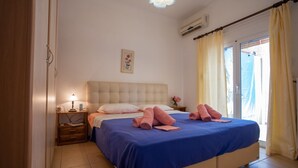 Een slaapkamer met een bed, nachtkastjes, een lamp en een raam met gordijnen.