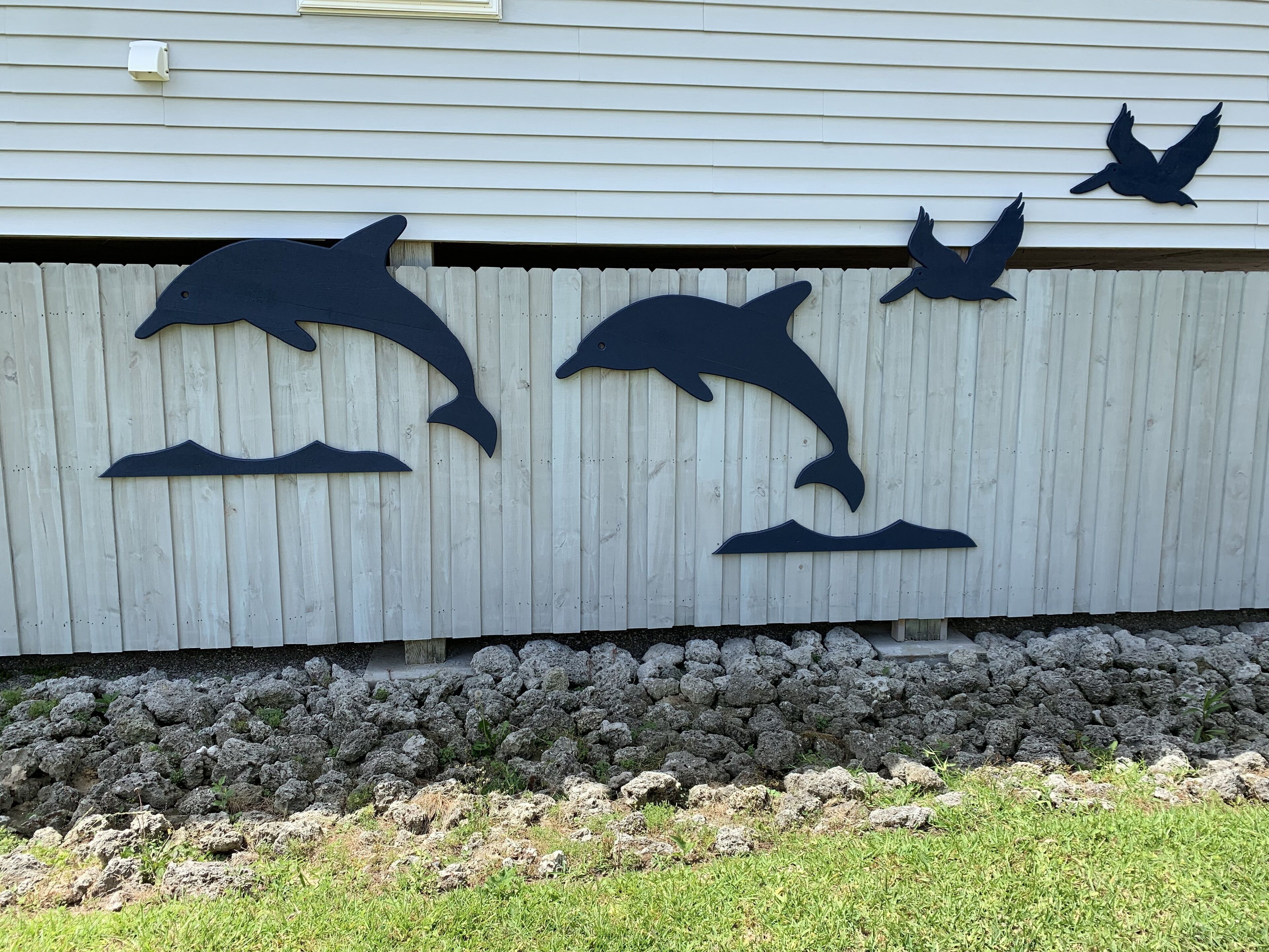 A wall with silhouettes of a dolphin, a bird, and a fish.