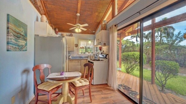 A compact kitchen with a dining area, a ceiling fan, and a view of the outdoors. - Delray Lonepine Estate Guest House (Delray Beach)