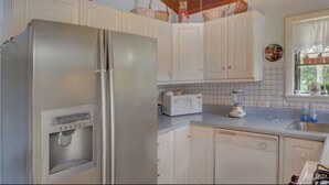 A kitchen with white cabinets, a stainless steel refrigerator, a microwave, and a built-in ice and water dispenser. - Delray Lonepine Estate Guest House (Delray Beach)