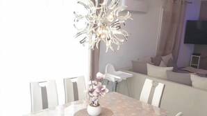 A dining area with a table, chairs, a chandelier, and a sofa in the background. - Villa festival avignon (Avignon)