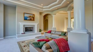 A spacious living room with a fireplace, a large sofa set, and a decorative rug. - Villa del Sol (Tempe)