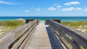 A wooden boardwalk leading to a beach with clear skies and calm waters. - Gulf Shores Surf and Racquet Club 211A | King Bd | Boat Launch |Trailer Parking (Gulf Shores)