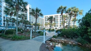 A resort with a pool, palm trees, and a building with multiple balconies. - Gulf Shores Surf and Racquet Club 211A | King Bd | Boat Launch |Trailer Parking (Gulf Shores)