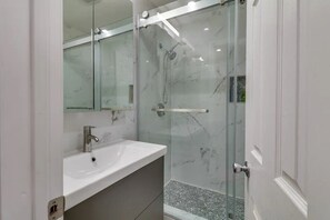 Een bad/douchecombinatie, een haardroger, een bidet, handdoeken