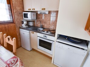 A compact kitchen with a microwave, coffee maker, sink, oven, and dishwasher.