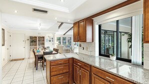 Una cocina moderna con armarios de madera, encimeras de granito y un amplio ventanal con vistas al exterior.