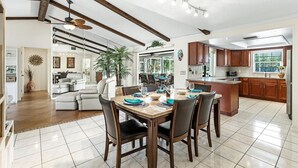 Una cocina amplia con comedor, vigas de madera y una isla grande.